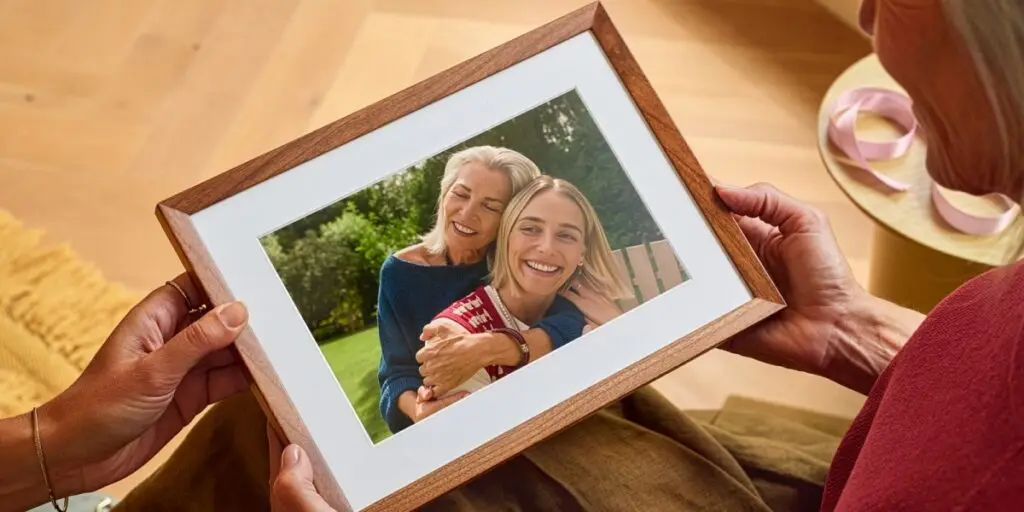 شخص يحمل إطار الصور الذكي Alexa Photo Frame بين يديه