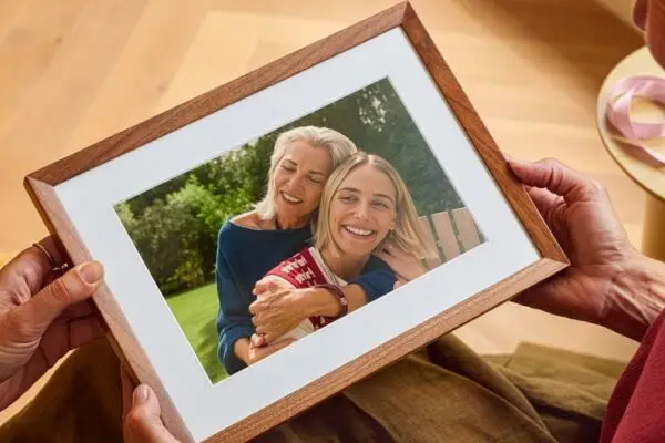 شخص يحمل إطار الصور الذكي Alexa Photo Frame بين يديه