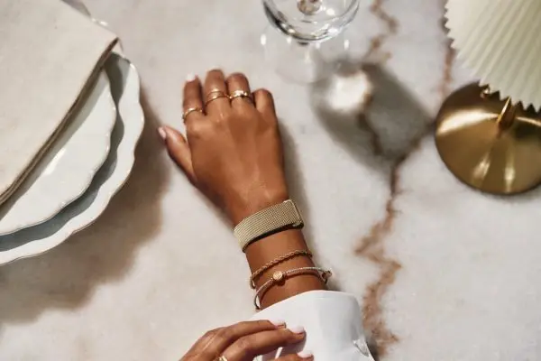 صورة تسويقية لساعة Fitbit Air الذكية مع سوار ذهبي على معصم شخص