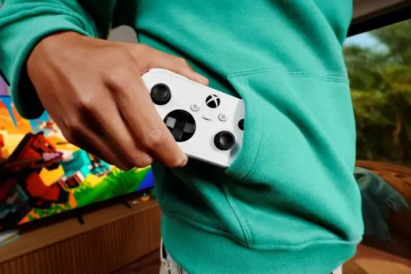 شخص يحمل يد التحكم XBOX Nano Controller بحجمها الصغير المدمج.